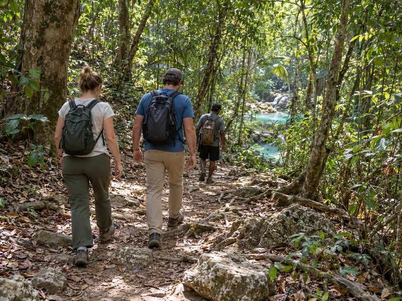 Visitors walking along a shaded path toward Mata Jitu Waterfall on Moyo Island